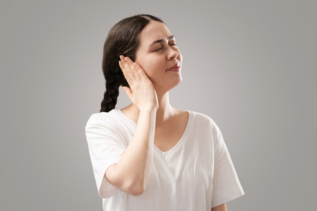Young woman holding her had against her right ear in pain